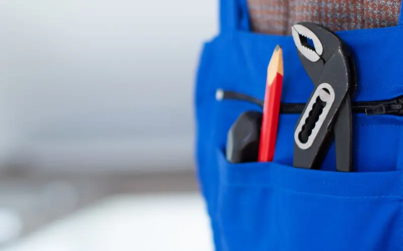 Werkzeugtasche eines Hausmeisters mit Zange und Zimmermannsbleistift